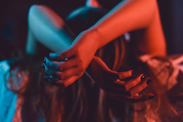 close up on female young woman's girl's beautiful hands woman lying on the bed with black nail polis
