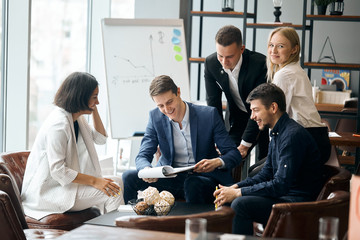 cheerful leader and his team analizing the document, woman in striped stylish suit offering goods , service for firm