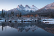 First snow Almost near perfect reflection of the Three Sisters Peaks in the Bow River. Canmore in Banff National Park Alberta Canada Snow-covered winter mountain in a winter atmosphere. Beautiful day