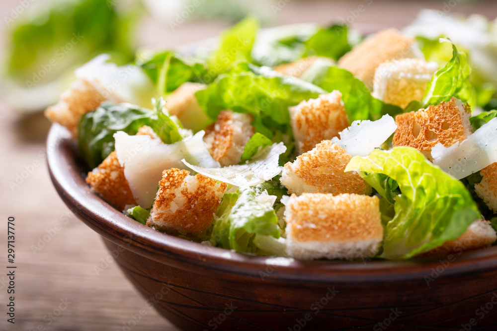 Bowl of caesar salad with cheese and croutons - obrazy, fototapety, plakaty 