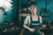 The concept of small business, feminism and women's equality. A young woman in overalls holds a large wrench and looks away