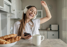 Young Lady Can Not Stop Dancing While Listening To The Music Alongside With Breakfast
