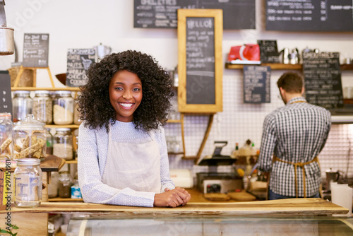 Fotografía Smiling young African American entrepreneur working behind her cafe counter
