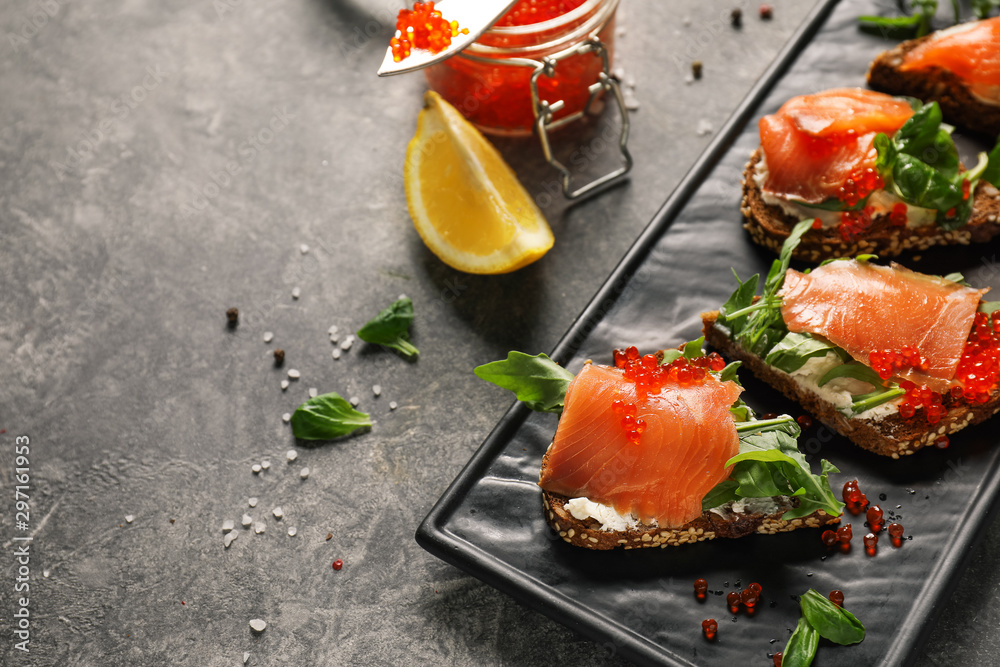 Plate with tasty sandwiches on grey background