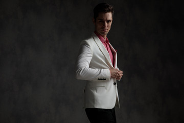 Poster - Side view of a attractive elegant man unbuttoning his jacket