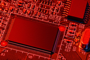 printed circuit board and microchip, or cpu, in red light closeup - electronic component for digital