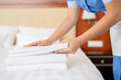 © pressmaster - Hands of young contemporary chamber maid making stack of white fresh towels