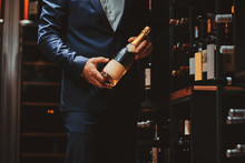 Elegant Man In Suit At Wine Cellar With Bottle Of Wine