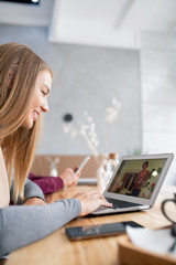 Poster - Smiling blonde girl communicating with her friend unpacking box with purchase