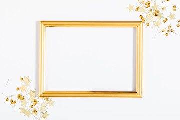 Wall Mural - Christmas modern composition. Golden photo frame, golden decorations, confetti, stars on white background. Flat lay, top view, copy space