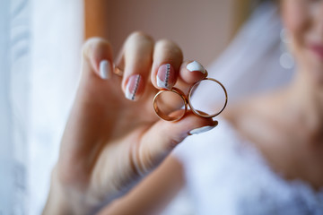 gold wedding rings in the hands of the newlyweds