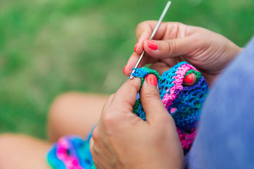 Craftswoman's hands knitting shawl with crochet