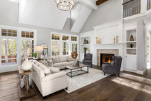 Beautiful Living Room In New Traditional Style Luxury Home. Features Vaulted Ceilings, Fireplace With Roaring Fire, And Elegant Furnishings.
