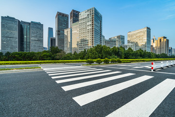 empty road with zebra crossing and skyscrapers in modern city.