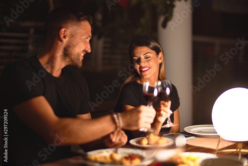 Fotografía Young beautiful couple dinning on celebration toasting and smiling at terrace