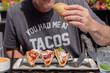 man eating tacos in summer