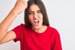 © Krakenimages.com - Young beautiful woman wearing red casual t-shirt standing over isolated white background annoyed and frustrated shouting with anger, crazy and yelling with raised hand, anger concept