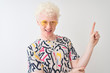 © Krakenimages.com - Young albino blond man wearing colorful t-shirt and sunglasses over isolated red background with a big smile on face, pointing with hand and finger to the side looking at the camera.