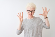Young Albino Blond Man Wearing Striped T-shirt And Glasses Over Isolated White Background Showing And Pointing Up With Fingers Number Nine While Smiling Confident And Happy.