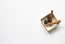 Pine Cones And Cinnamon Sticks In A Bowl On White Background. Autumn Concept