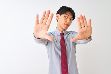 Chinese businessman wearing elegant tie standing over isolated white background doing frame using hands palms and fingers, camera perspective