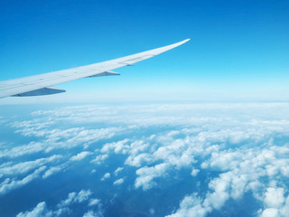 Wing of airplane flying against blue sky