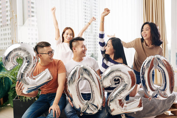 Poster - Excited friends with foil 2020 balloon having small New Year party at home