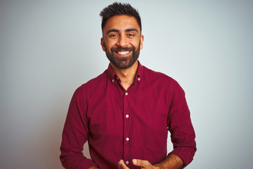 young indian man wearing red elegant shirt standing over isolated grey background with hands togethe