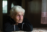 Fototapeta  - Portrait of sad elderly woman in the his house.