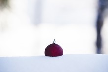 Closeup Of A Red Ornament In The Snow