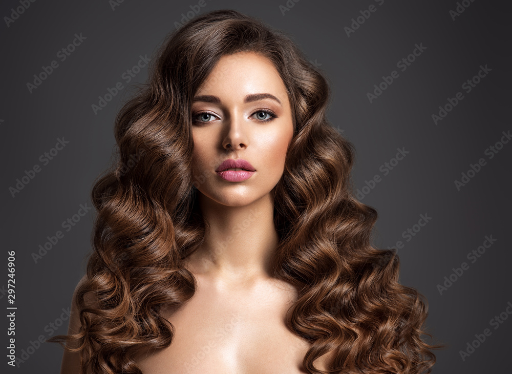 Beautiful woman with long brown hair. Beautiful face of an attractive model with natural makeup. Beauty  of curly hair. Closeup portrait  of caucasian stunning girl. - obrazy, fototapety, plakaty 