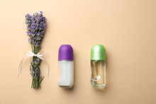 Female Deodorants And Lavender Flowers On Beige Background, Flat Lay