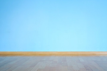 laminate flooring, plinth and large blue concrete wall with empty space