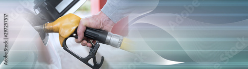 Fotomural Hand holding fuel pump nozzle and refilling car; panoramic banner