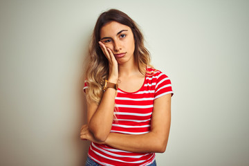 Sticker - Young beautiful woman wearing red stripes t-shirt over white isolated background thinking looking tired and bored with depression problems with crossed arms.