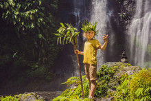 Cute Boy Depicts The King Of The Jungle Against The Backdrop Of A Waterfall. Childhood Without Gadgets Concept. Traveling With Children Concept. Childhood Outdoors Concept