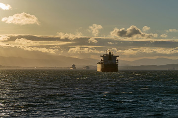 Cargo ship on the road at sunset. Logistics import and export business.