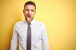 © Krakenimages.com - Young handsome business man wearing elegant white shirt over yellow isolated background sticking tongue out happy with funny expression. Emotion concept.