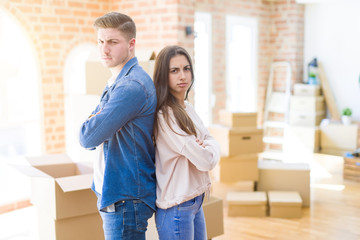 Canvas Print - Beautiful young couple moving to a new house skeptic and nervous, disapproving expression on face with crossed arms. Negative person.