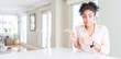 © Krakenimages.com - Wide angle of beautiful african american woman with afro hair Pointing aside worried and nervous with both hands, concerned and surprised expression