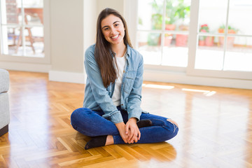 Sticker - Beautiful young brunette woman smiling cheerful looking at the camera with a big smile on face sitting on the floor at home with sunlight at the background