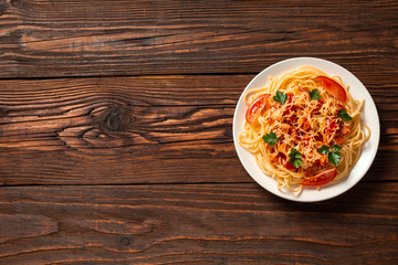 Wall Mural - Pasta carbonara with tomato sauce and minced meat, grated parmesan cheese and fresh parsley - homemade healthy italian pasta on rustic wooden background. Flat lay. Top view.