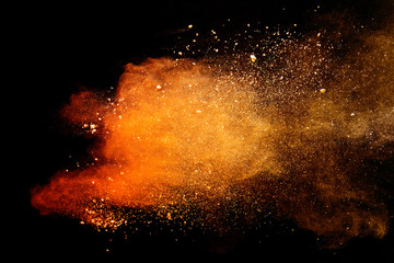 Wall Mural - abstract orange powder explosion isolated on black background.