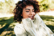 © iuricazac - Outdoor close-up portrait of beautiful young woman smiling with closed eyes, posing against nature background with curly hair, have positive expression, wearing knitted sweater. People, lifestyle
