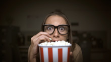 Woman Watching A Horror Movie And Eating Popcorn