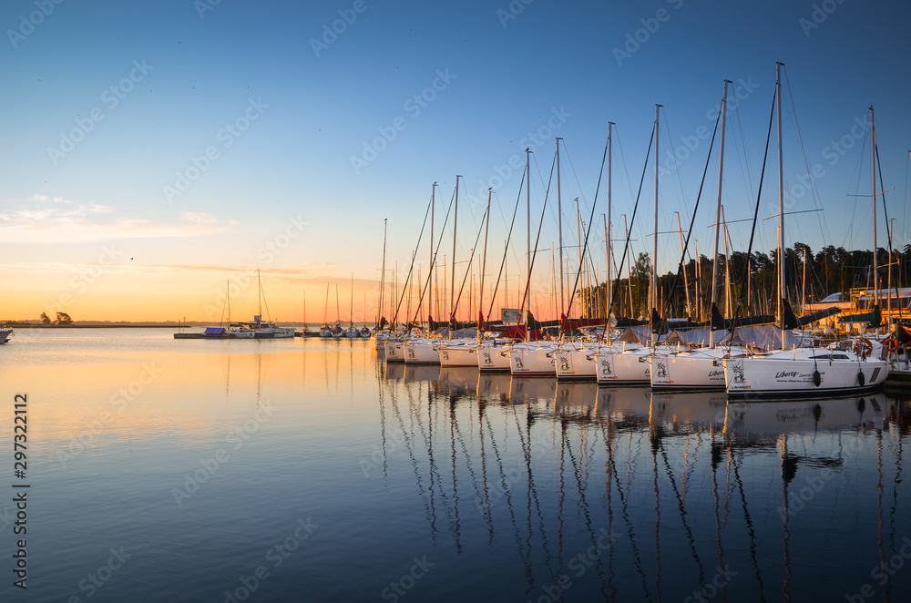 Boats docking in the marina at the Niegocin Lake during sunrise. Wilkasy, Masuria , Poland. - obrazy, fototapety, plakaty 