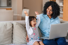 Laughing Little Girl And Mother Watching Something On A Laptop