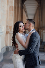 Young fashion couple posing. Young elegant sexy couple hugs, wearing suit and white luxury dress, enjoy their honeymoon, luxury style, love, stylish lovers.  Feelings of love between two people. 