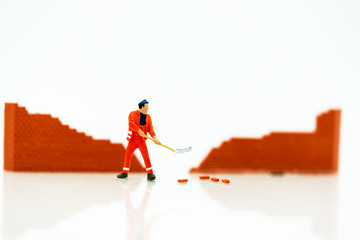 Miniature people: Worker fix the wall before the world. Concepts of finding a solution, problem solving and challenge.