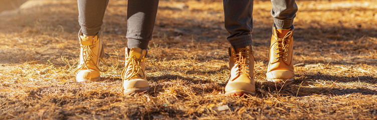 Panoramic view of two human feet hiking in woods